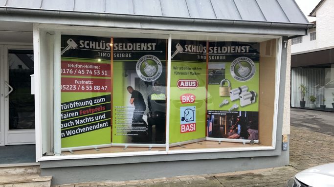 Schaufenster mit bunten Werbebannern für Solartechnologie und -dienstleistungen.