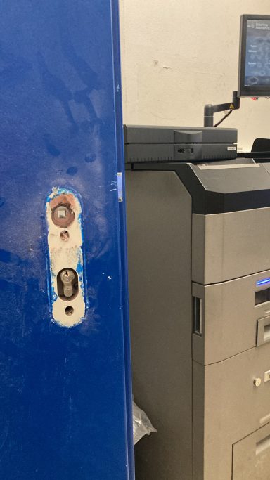 Blaue Tür mit Schloss und nebenstehendem Aktenschrank.
